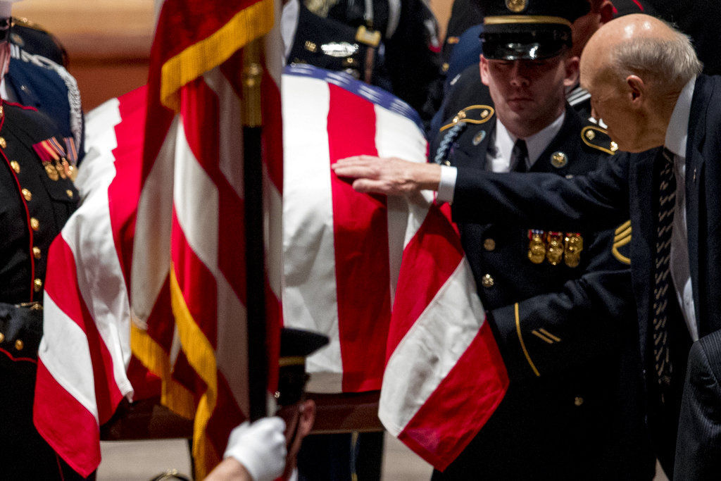Former Sen. Alan Simpson, R-Wyo, touches the flag-draped casket
